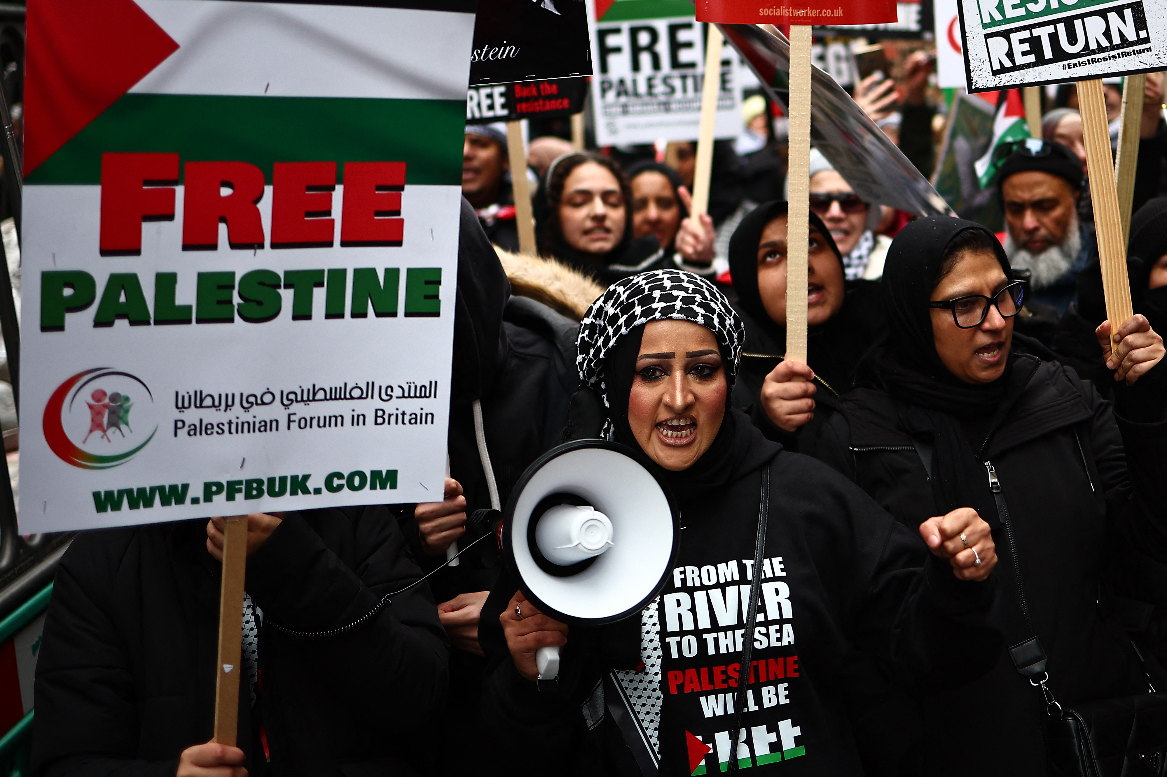 A pro-Palestine demonstrator with a megaphone marches in London