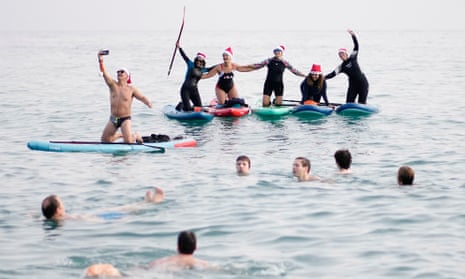 People celebrate New Year's Day by taking a traditional first bath of the year at Sant Sebastia beach in Barceloneta neighbourhood, Barcelona, on January 1, 2024.