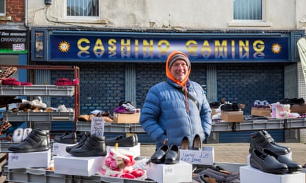 Tony Shu, a market trader, selling shoes