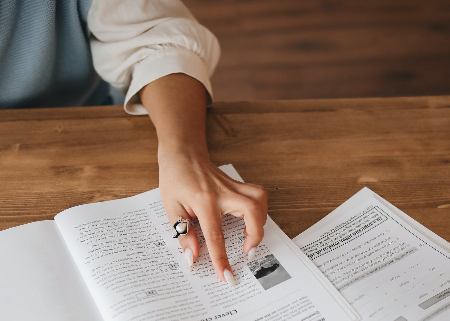 A hand hovers over study material