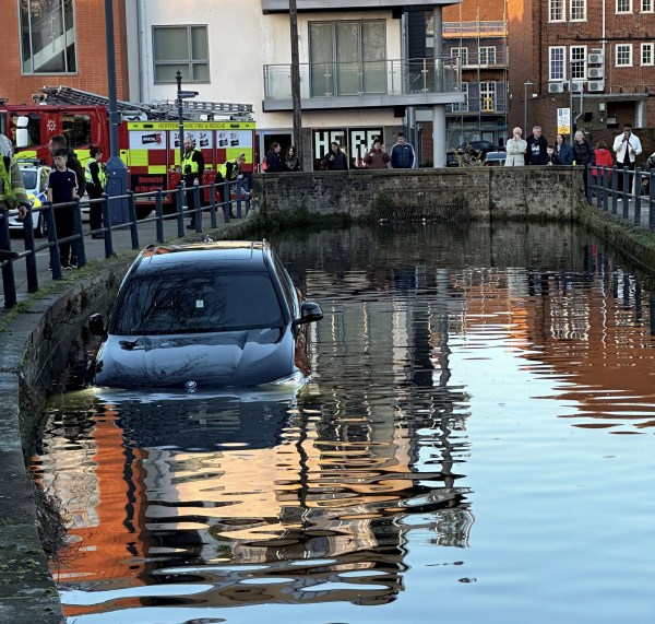 The electric BMW which ended up underwater after a parking mishap in Hitchin town centre, Photo released February 25 2024. See SWNS story SWNAriver. A BMW driver was left counting the cost after they accidentally smashed their ?63,000 electric vehicle through safety barriers - and plunged into a river. Residents in Hitchin town centre, Herts, were left stunned when the two-tonne SUV took a wrong turn and landed in the River Hiz yesterday (Sat). Eyewitnesses said the BMW IX3 electric SUV was parked up at the Portmill Lane West Car Park before crashing through the railings along the waterway. Despite the car becoming almost fully submerged, it is believed the driver got out unharmed.