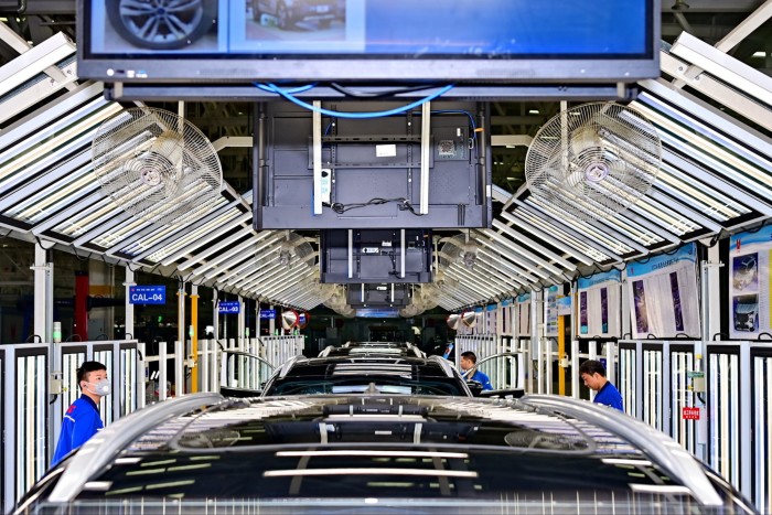 Employees work on the assembly line of electric vehicles in a factory of Jiangling Motors