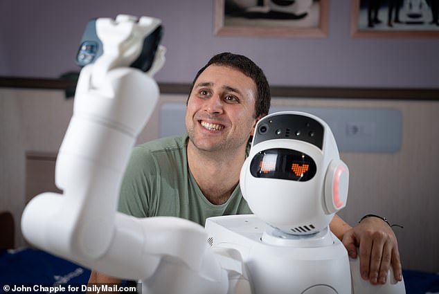 Other very high-tech robots, such as the 2ft tall Japanese nurse-bot Aeo have been hailed as a potential solution to the NHS workforce crisis. Pictured: The Mail on Sunday's Health Editor Ethan Ennals with Aeolus Robotics, Aeo