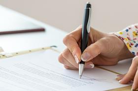 An anonymous woman signs a document