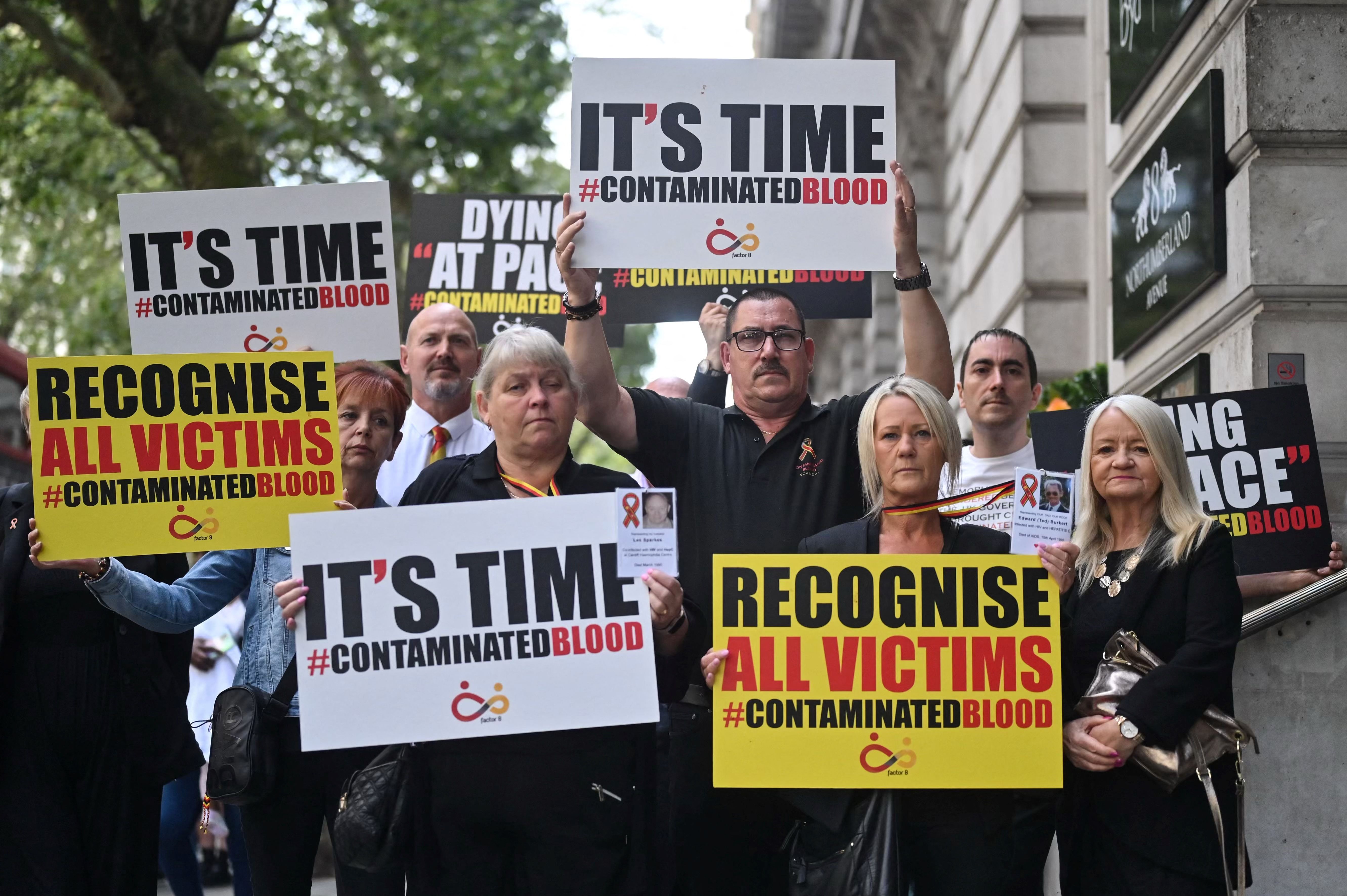  Demonstrators hold placards calling for all victims to be recognised