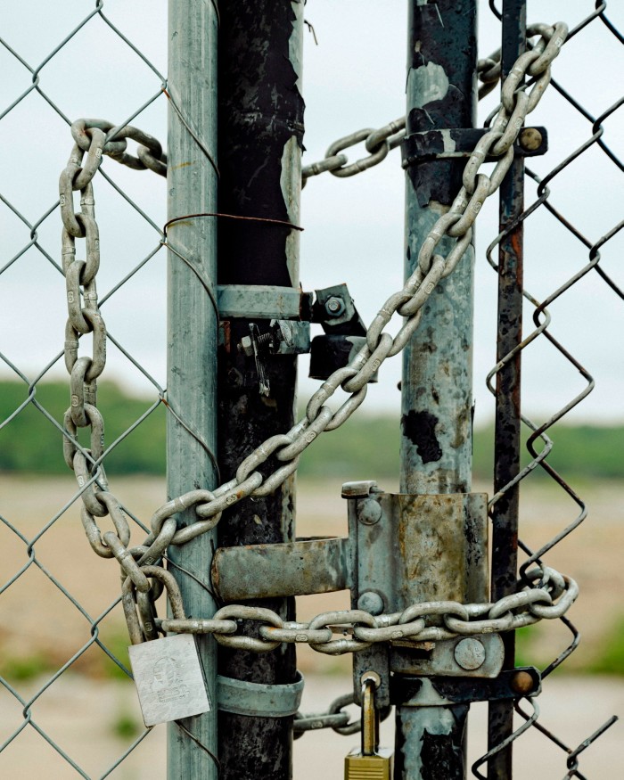 A chain and padlock on a wire fence