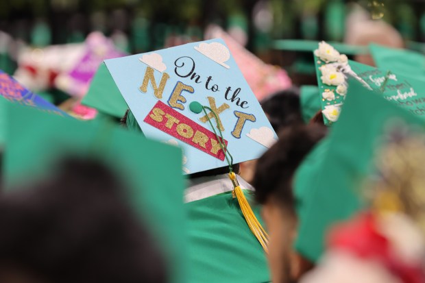 Eisenhower High School students decorate their caps for their graduation...