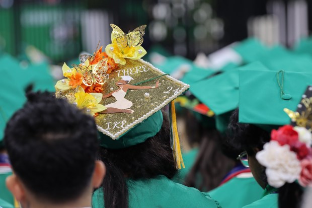 Eisenhower High School students decorate their caps for their graduation...