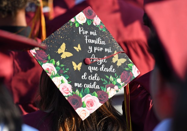 A graduate’s decorated cap says in part, for my family,...