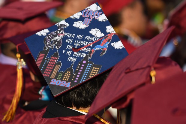 A graduate’s decorated cap says, for my parents who arrived...