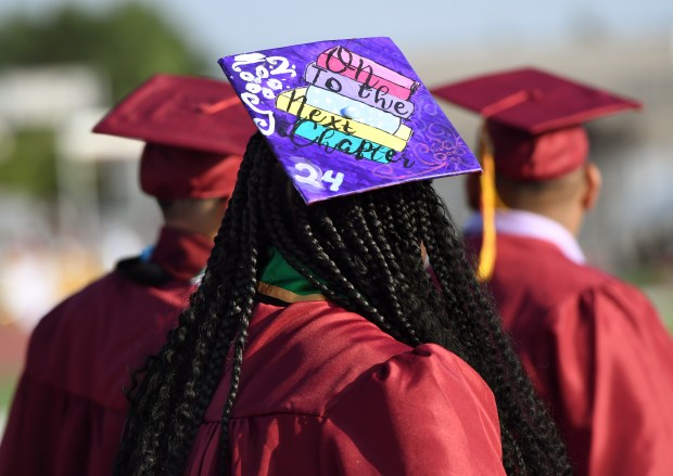 A graduate’s decorated cap shares hope for the future during...