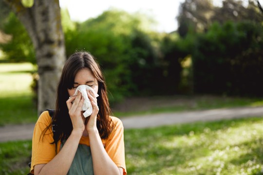 Woman sneezing in the park