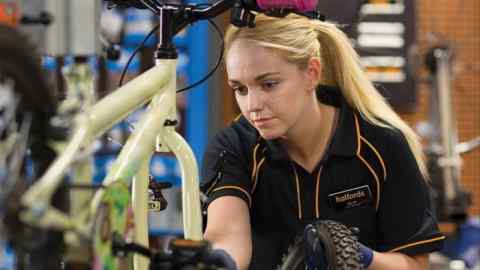 A Halfords employee services a bicycle