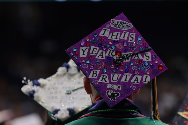 Eisenhower High School students decorate their caps for their graduation...