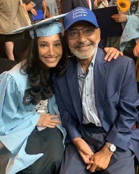 woman in light blue graduation cap and gown with man wearing blue baseball cap