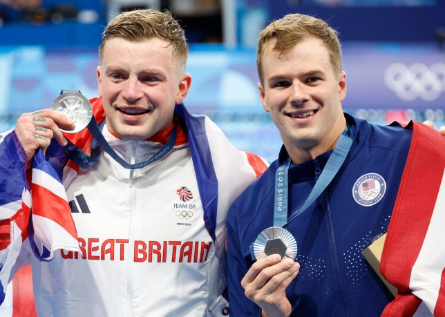 epa11504492 Silver medalist Adam Peaty of Britain (L) and bronze medalist Nic Fink of USA (R) pose after the Men 100m Breatstroke final of the Swimming competitions in the Paris 2024 Olympic Games, at the Paris La Defense Arena in Paris, France, 28 July 2024. EPA/FRANCK ROBICHON