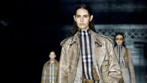 Reuters Models wearing Burberry outfits on a fashion show walkway