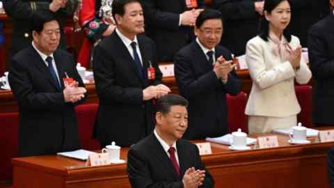 China’s President Xi Jinping applauds at the opening session of the National People’s Congress in Beijing on March 2024