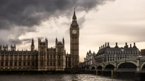 PA Media The Houses of Parliament and Big Ben under thick dark clouds.