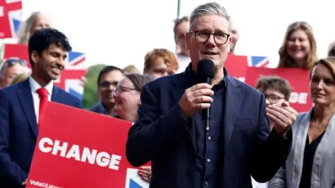 Reuters Labour Party leader Sir Keir Starmer speaks to supporters via a microphone during a general election campaign event before being elected prime minster