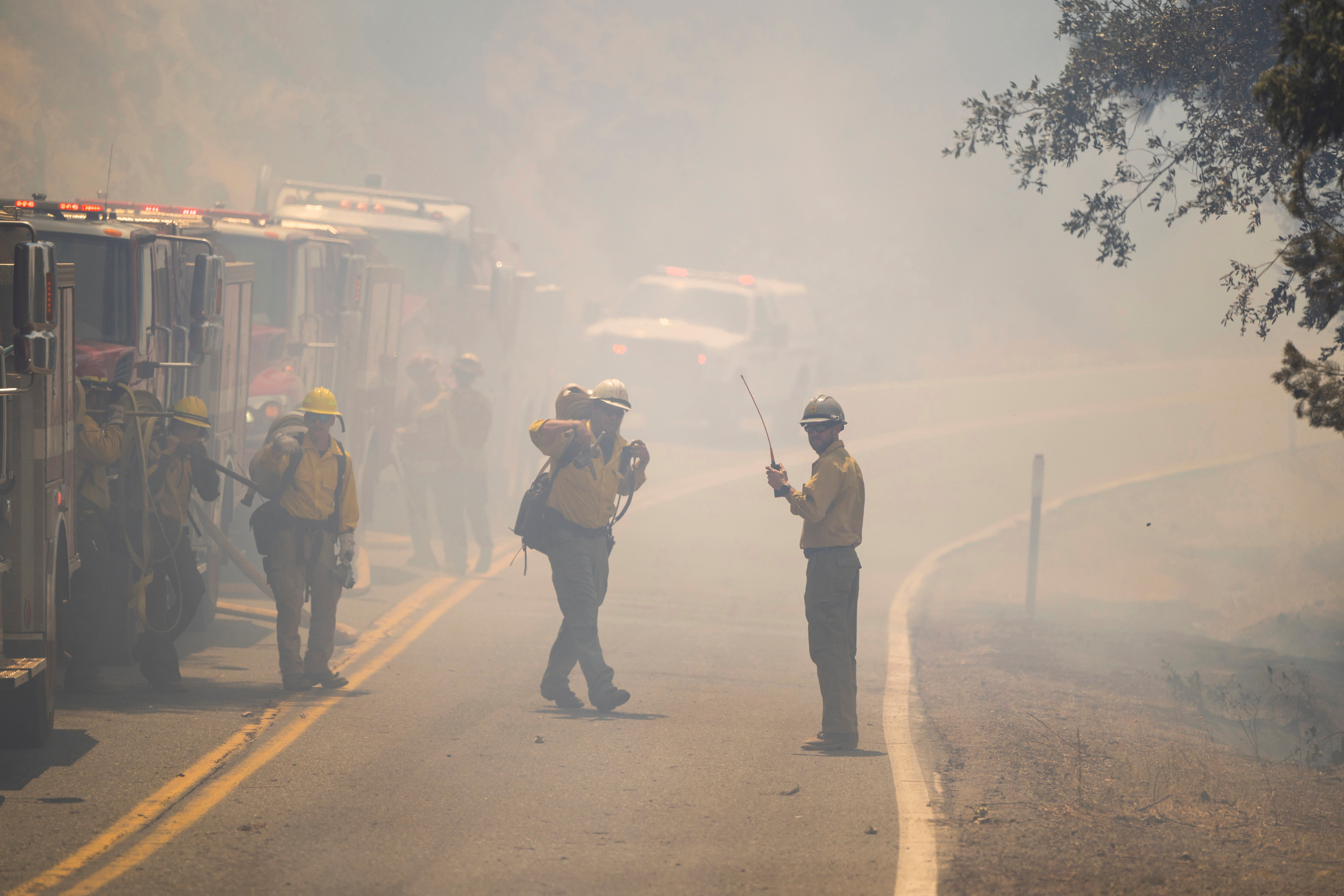 Fire crews walk through the smoke along Highway 32 as they battle the Park Fire near Forest Ranch, California, Sunday, July 28, 2024. (AP Photo/Nic Coury)