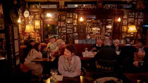 Customers drink inside the Heron Pub in West London