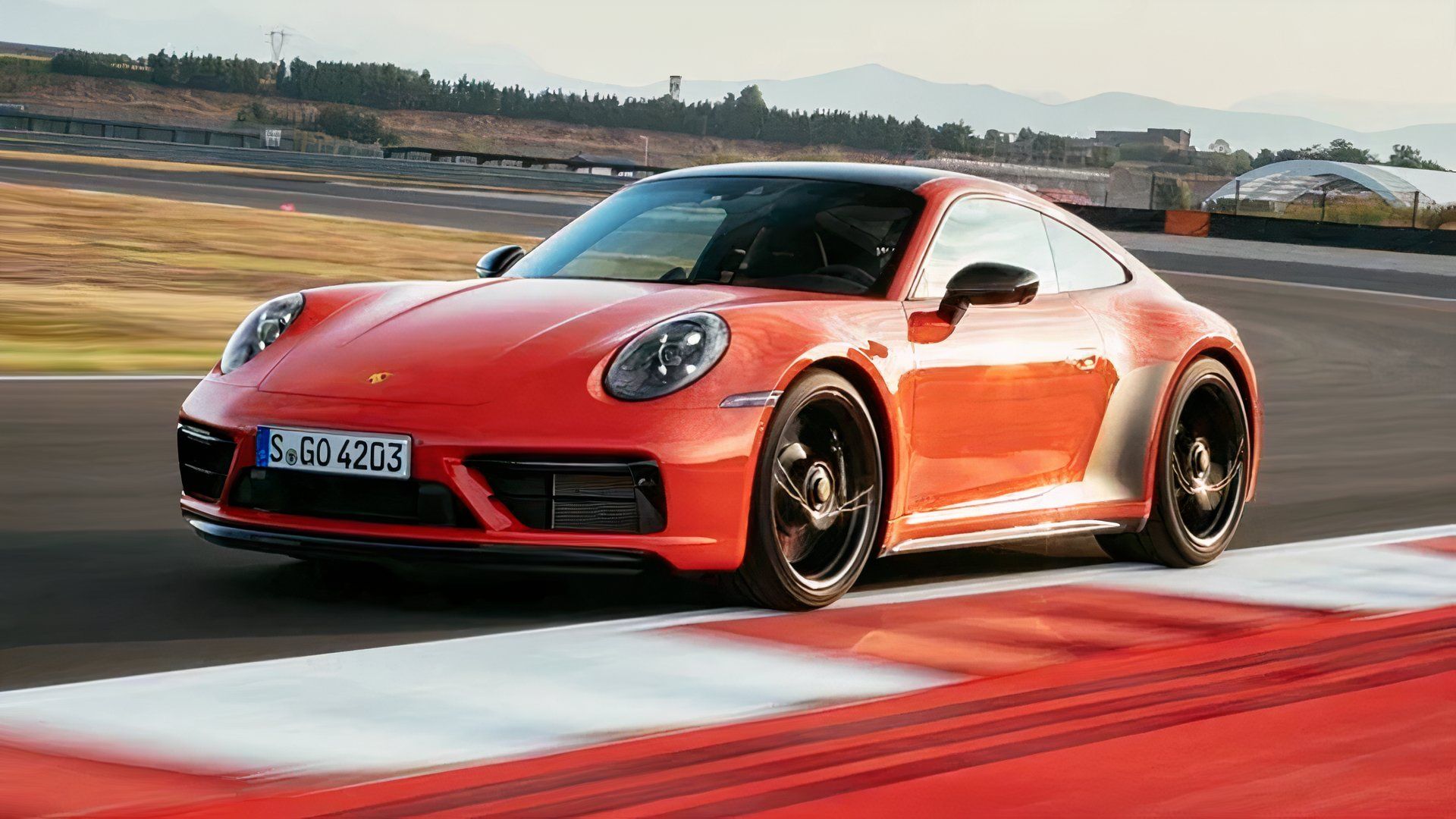 2024 Porsche 911 Carrera 4 GTS Coupe In orange Driving on race track