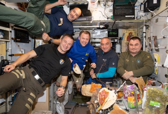 Astronauts posing around their food.