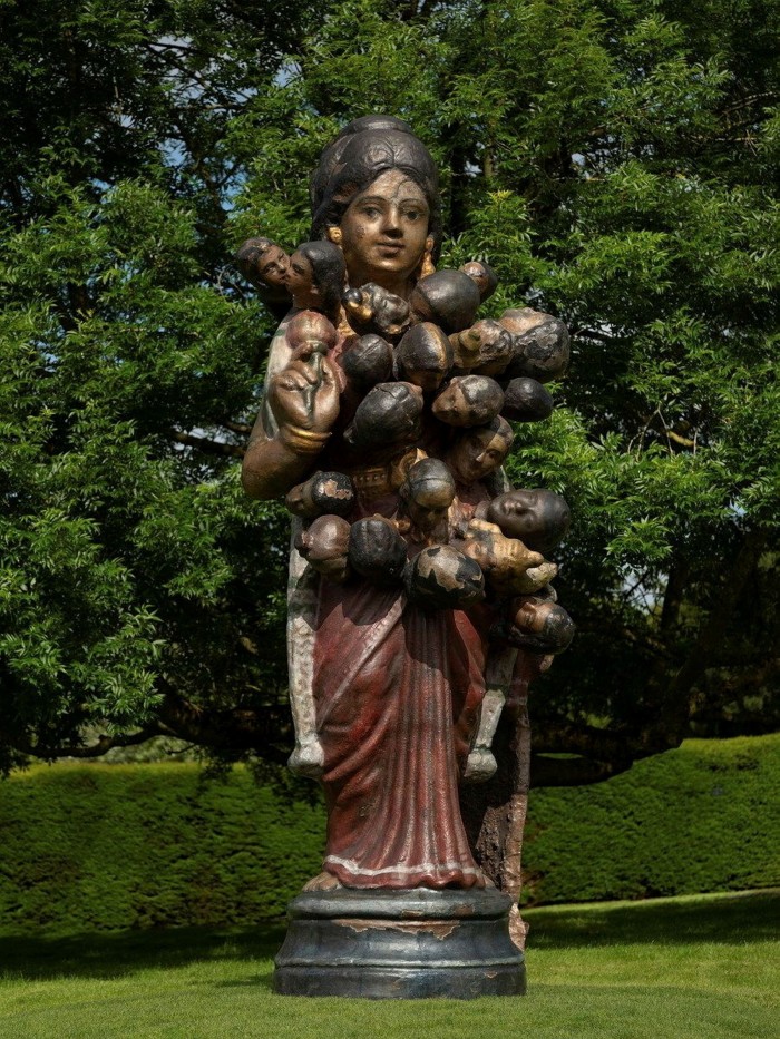 A statue of a mother-goddess with the heads of children growing out of her torso