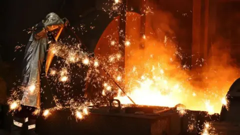 Getty Images Sparks fly as a worker takes a sample of molten iron flowing from a blast furnace in Duisburg, Germany