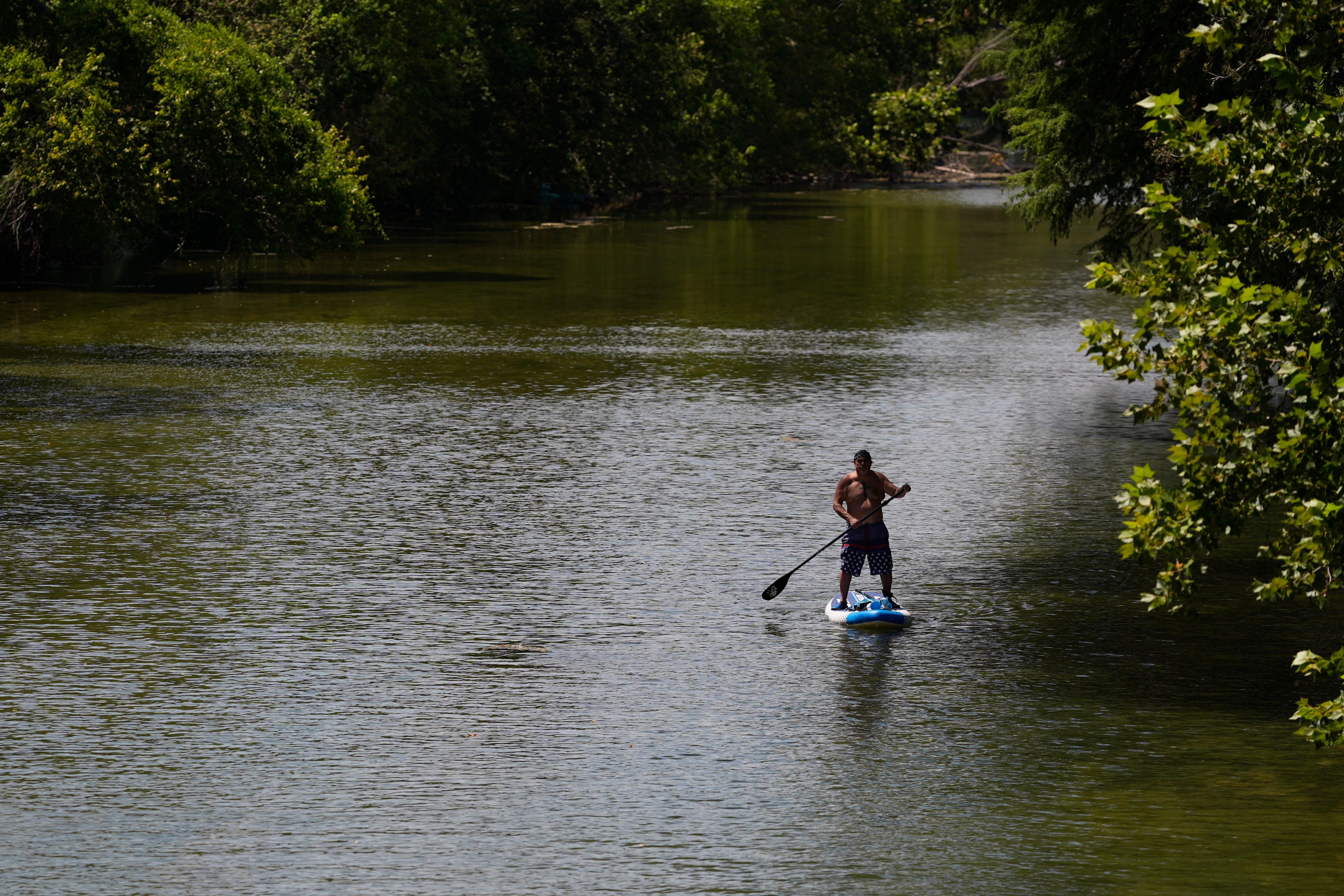 A paddler moves down the Guadalupe River on Wednesday in New Braunfels, Texas