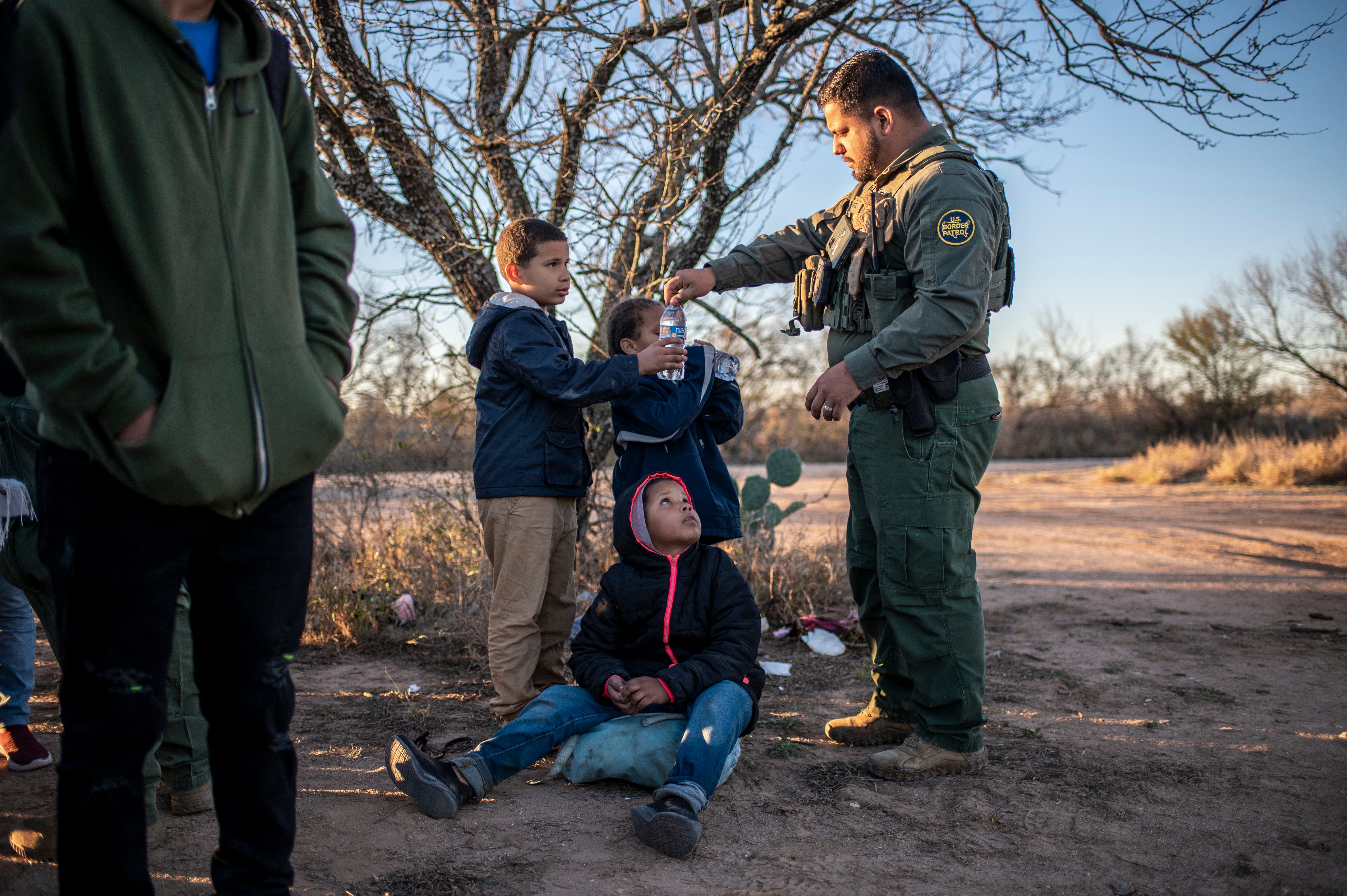 A Border Patrol agent gives unaccompanied minors water outside Eagle Pass, Texas in early February