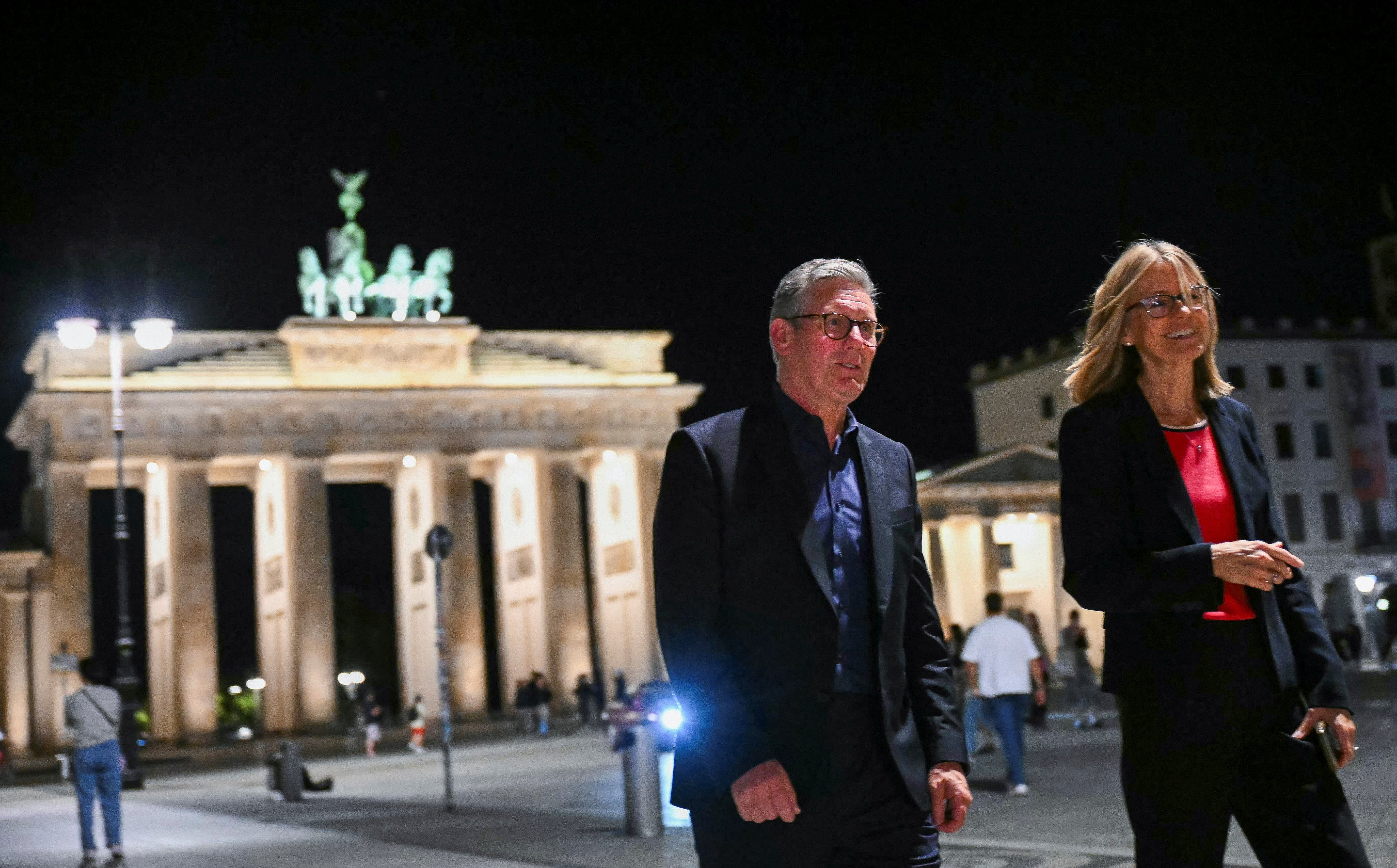 Britain's Prime Minister Keir Starmer and British Ambassador to Germany Jill Gallard walk near the Brandenburg Gate in Berlin