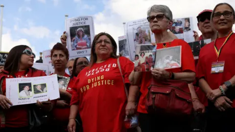 Reuters People affected by the contaminated blood scandal gather in Westminster for a vigil to remember those that lost their lives, ahead of the release of the final report of the Infected Blood Inquiry in May 2024