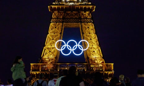 The Olympic rings displayed on the Eiffel Tower at night.