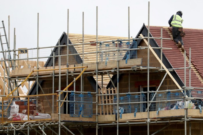 A roofer is shown on houses under construction 