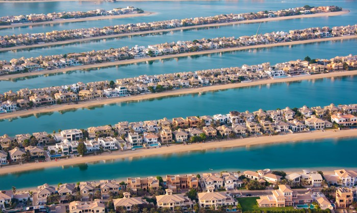 An aerial view of a highly organized and luxurious residential area with large, upscale homes built on artificial islands