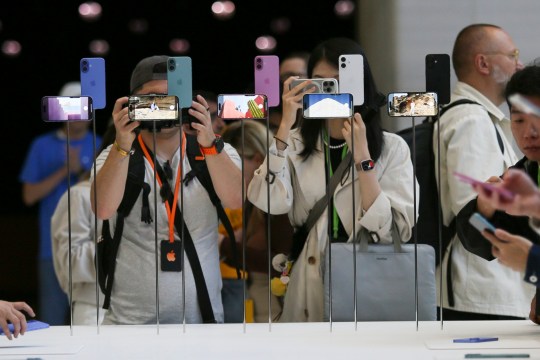 Attendees take a closer look at the Apple iPhone 16 during an announcement of new products yesterday