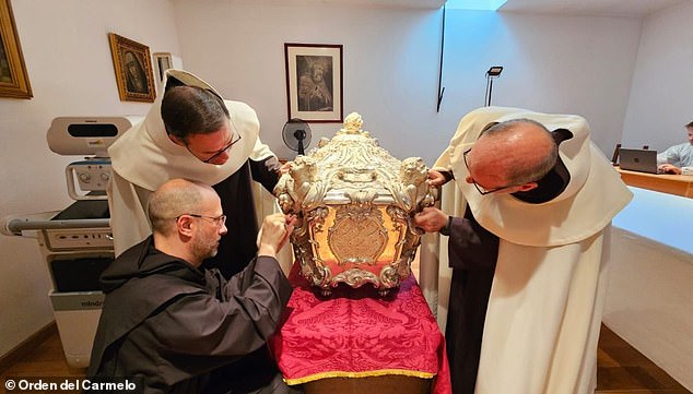 It is expected to take several months before doctors and scientists will get the results of their analysis back from a lab in Italy. Pictured: The silver coffin encased in marble of Saint Teresa of Avila