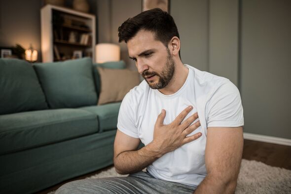 Mid adult man having heartache at hom