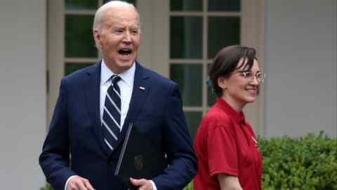 Joe Biden smiles while talking in the White House Rose Garden.