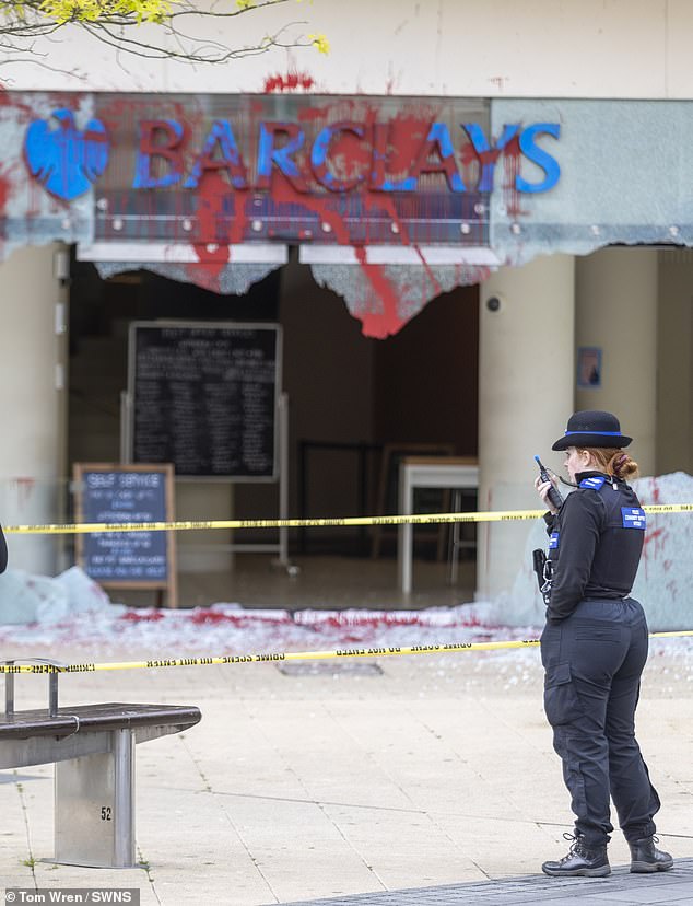 A police officer stands at the scene in Bristol after a Barclays branch was targeted by activists on June 10