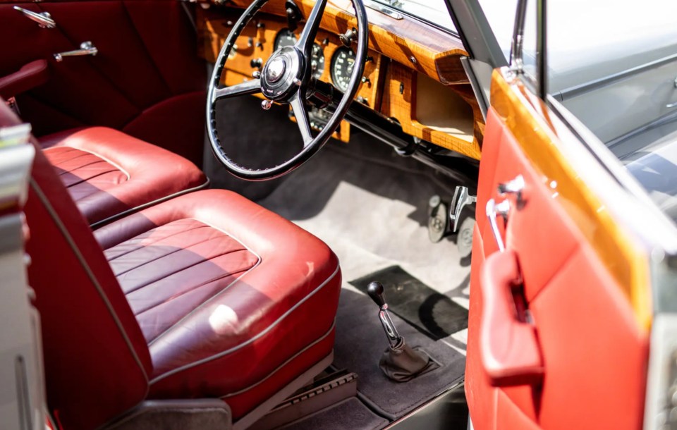 The car is also fitted with a red hide featuring grey piping and Art Deco-inspired door cards