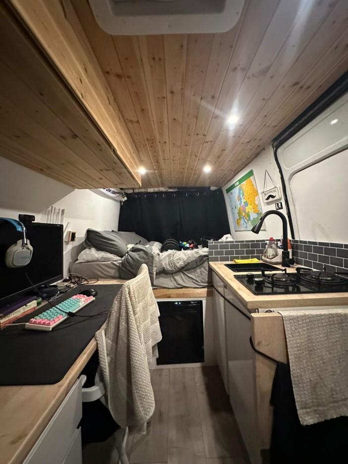 Inside Harry's van is a gaming PC, a bed, cupboards, a fridge, sink and stove