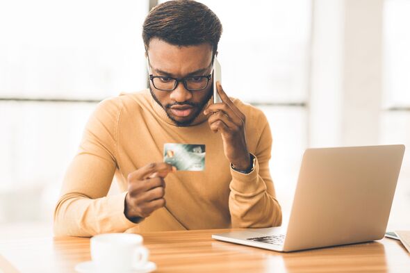 Man talking on phone holding credit card