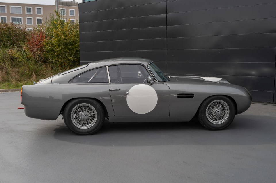 Side profile of a gray Aston Martin DB4 GT Continuation.