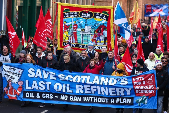 The protesters carry a banner reading: ‘Save Scotland’s last oil refinery’