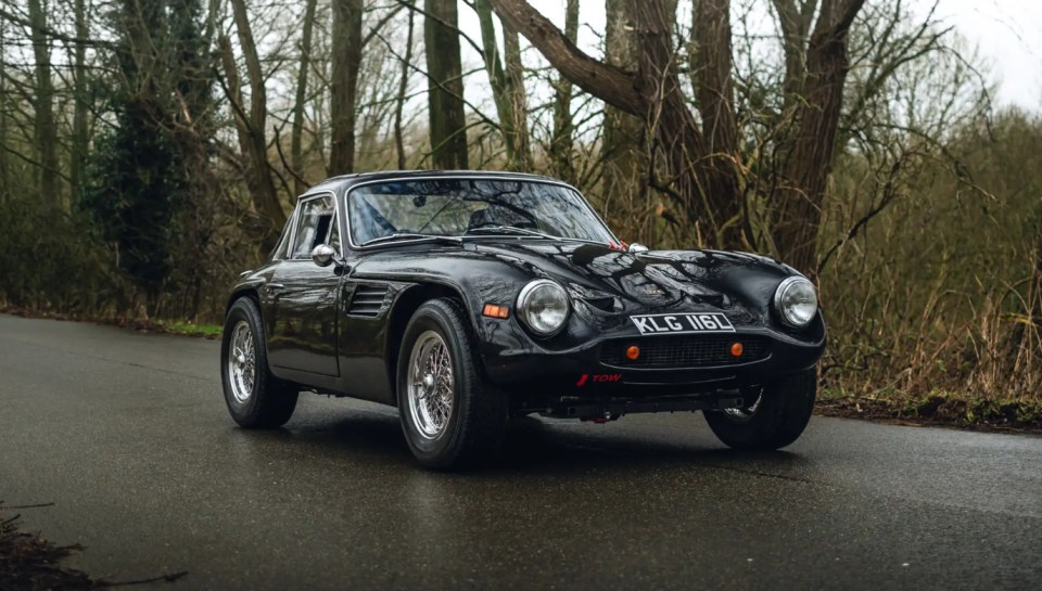 Black 1972 TVR Vixen S4 1300 driving on a road.