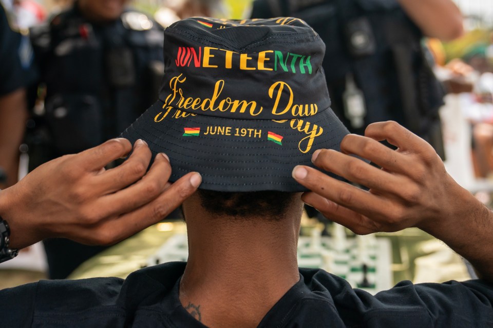 An attendee adjusts his Juneteenth-themed hat during a neighborhood Juneteenth festival on June 17, 2023 in Washington, DC.