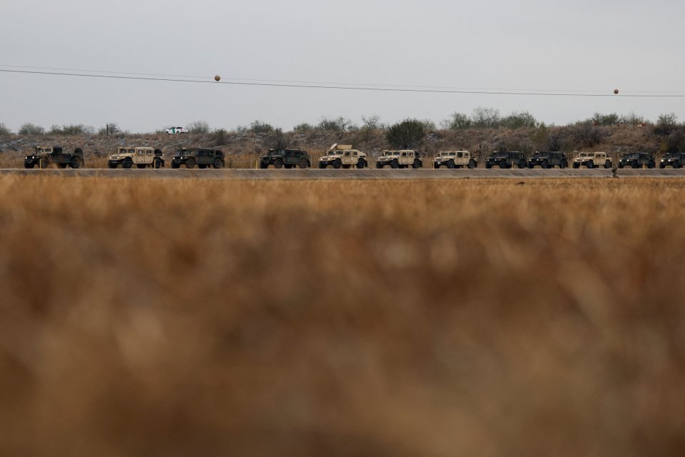 Military vehicles driving on a road.